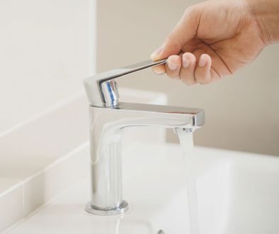 A close-up of a hand closing the water tap