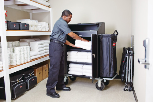 Man storing towels from housekeeping cart