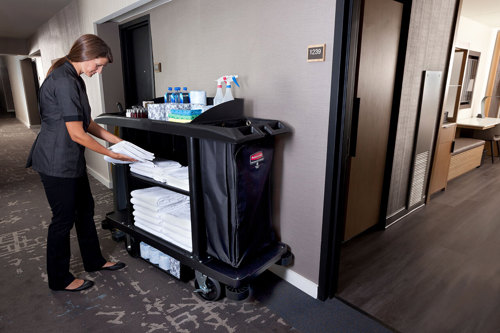 Lady getting towels from a housekeeping cart