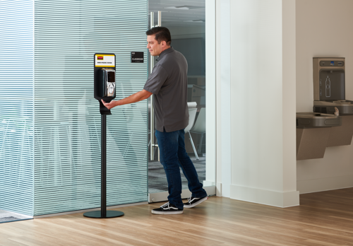 A person using Rubbermaid Hand Sanitiser machine