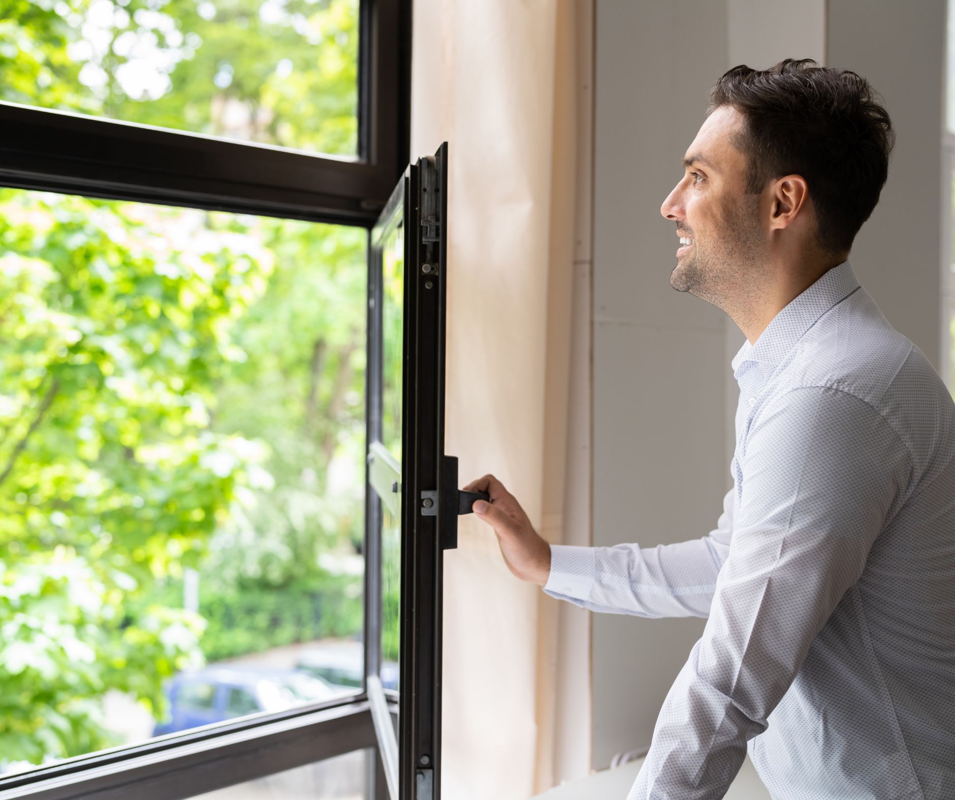 A man opening a window for fresh air