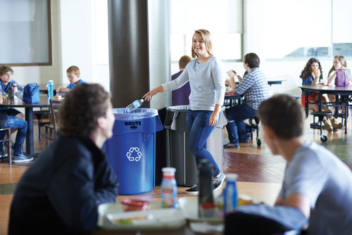 Woman putting bottle into brute bin at a cafeteria