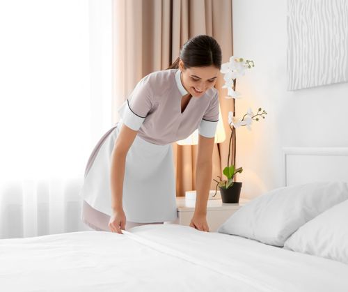 Hotel staff arranging bed