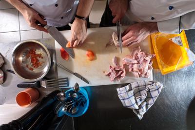 Chefs chopping raw meat on a chopping board