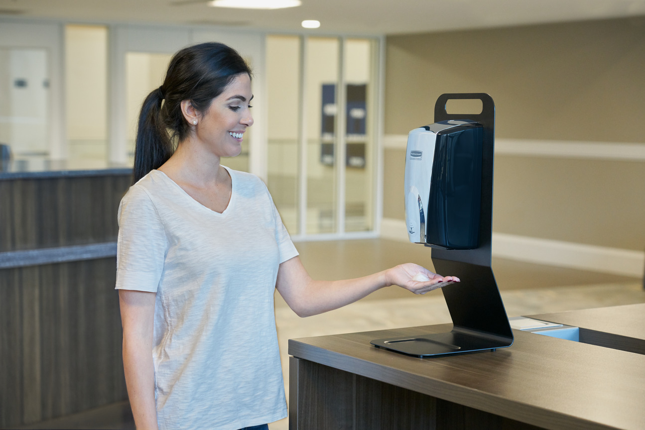 Image of a Woman using Rubbermaid Commercial Tabletop Stand Dispenser