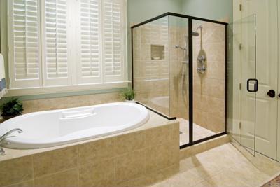 A clean hotel bathroom with a bath and a spotless glass shower door