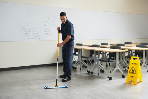 Man mopping classroom floor